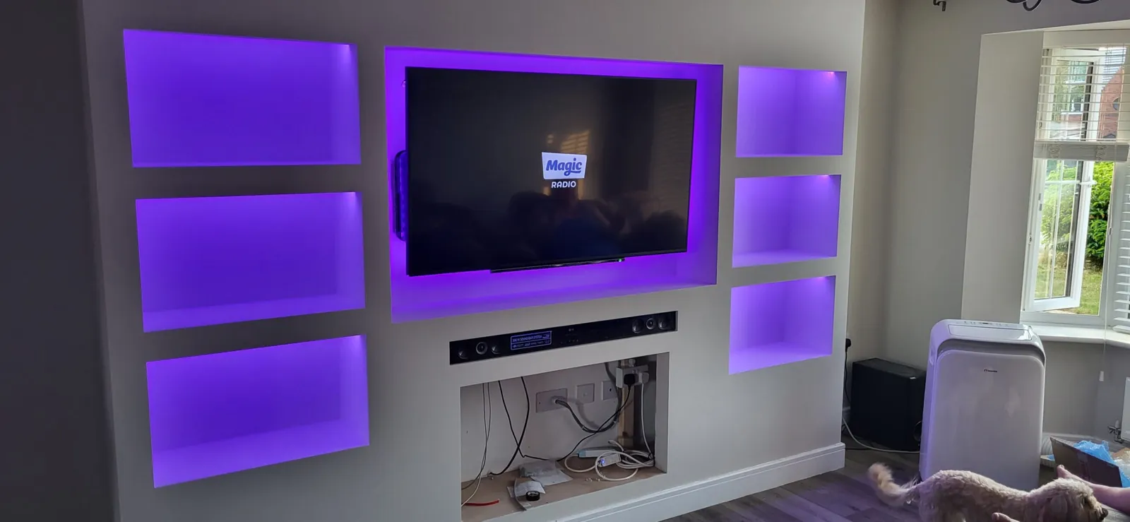 Finished media wall with recessed TV and LED alcove lighting installed by RJS Electrical