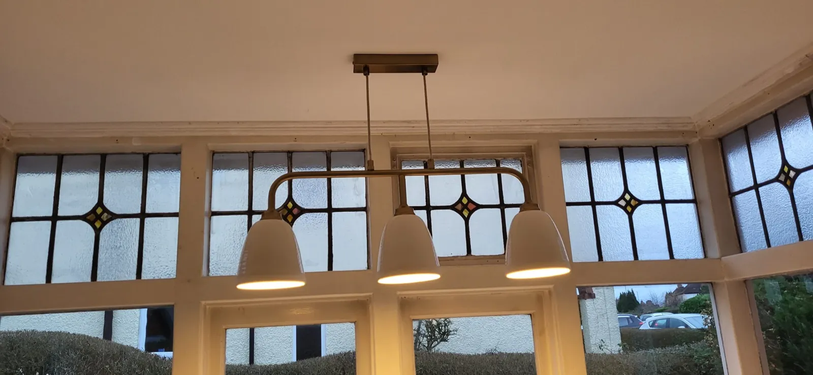Pendant and downlight scheme installed above a bay window dining area