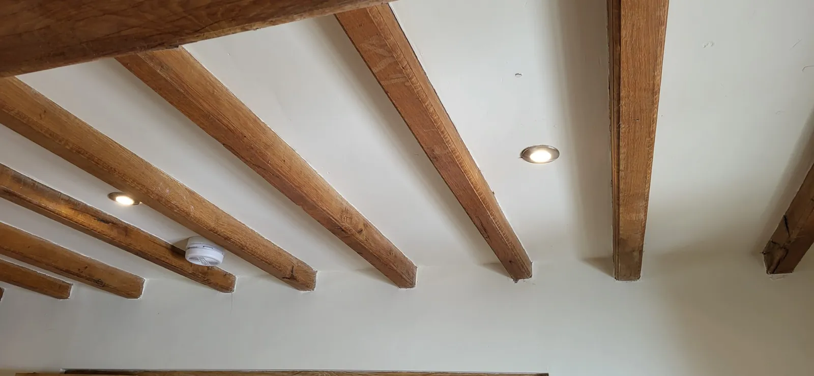 Recessed downlights fitted between exposed oak ceiling beams