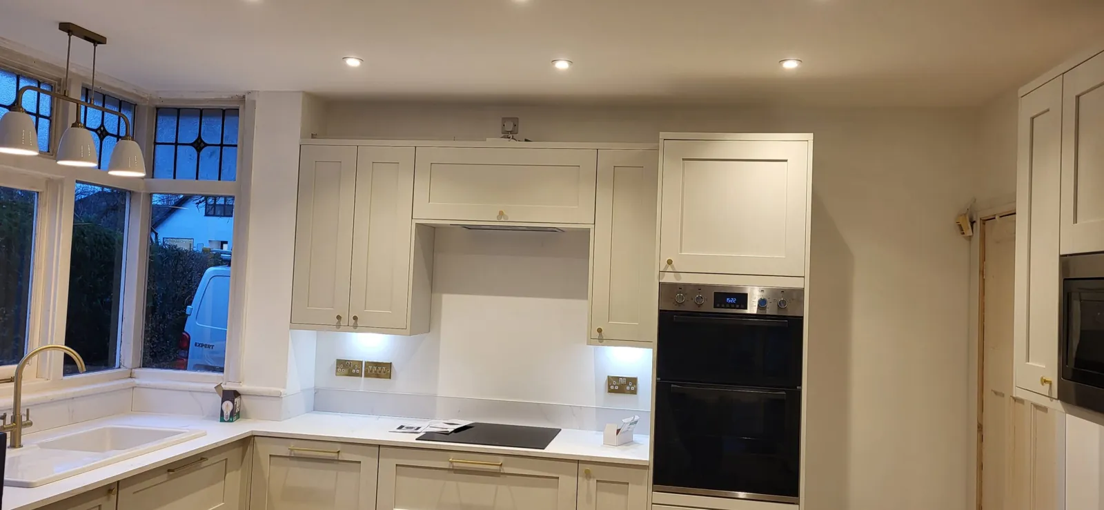 Cream shaker kitchen with pendant lighting and under cabinet lighting installed by RJS Electrical